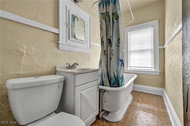 bathroom with vanity, a bath, and toilet