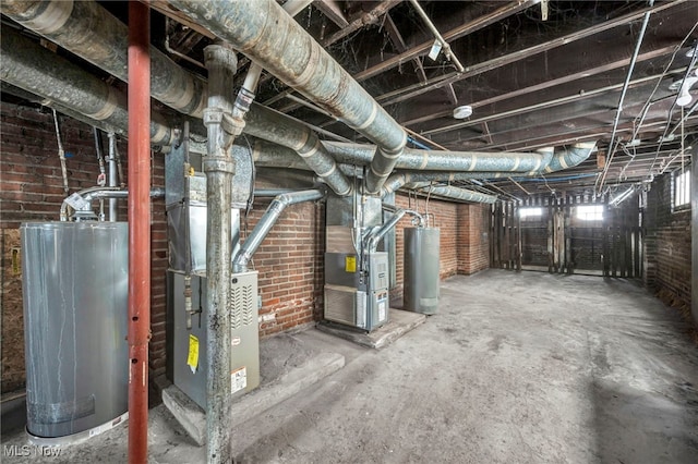 basement with heating unit, water heater, and brick wall