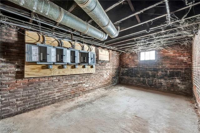 basement featuring brick wall and electric panel