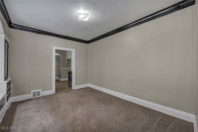 empty room with crown molding and carpet floors