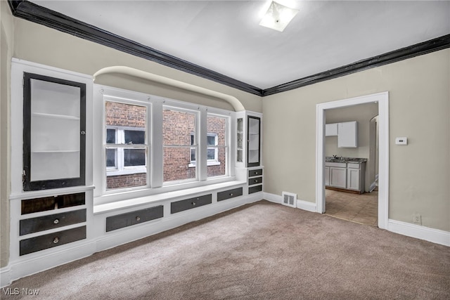 unfurnished living room featuring crown molding and light colored carpet