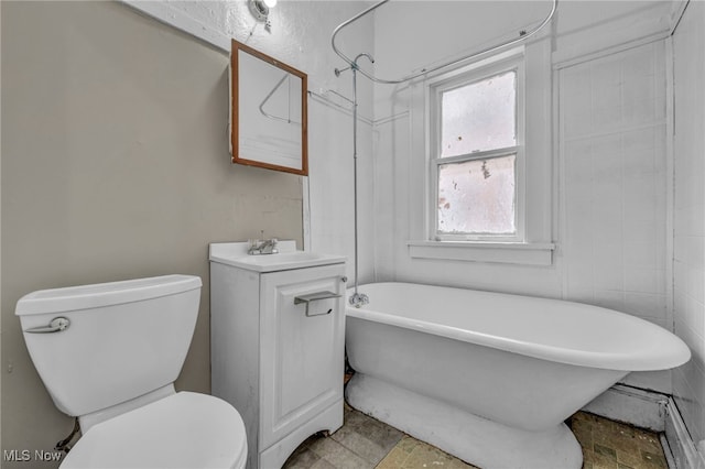 bathroom featuring vanity, a washtub, and toilet