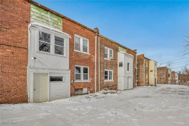 view of snow covered rear of property