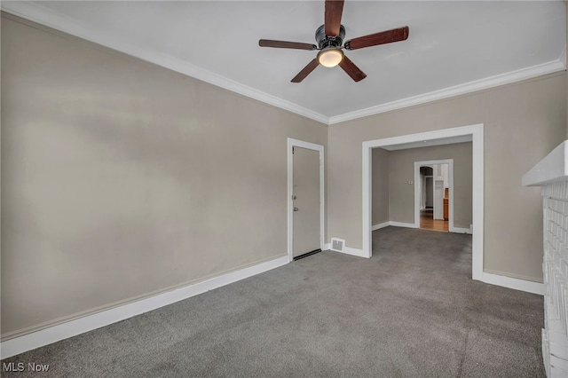 empty room with ornamental molding, ceiling fan, and carpet