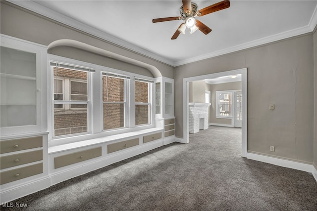 unfurnished room featuring ceiling fan, ornamental molding, a fireplace, and carpet floors