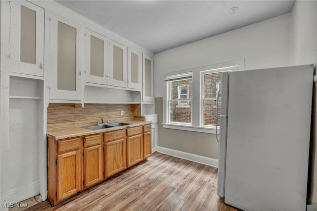 kitchen with sink, light hardwood / wood-style floors, and white refrigerator