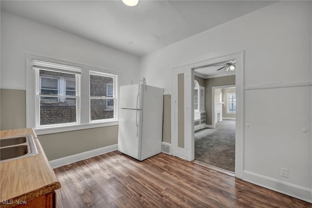 kitchen with hardwood / wood-style floors, sink, ceiling fan, and white refrigerator