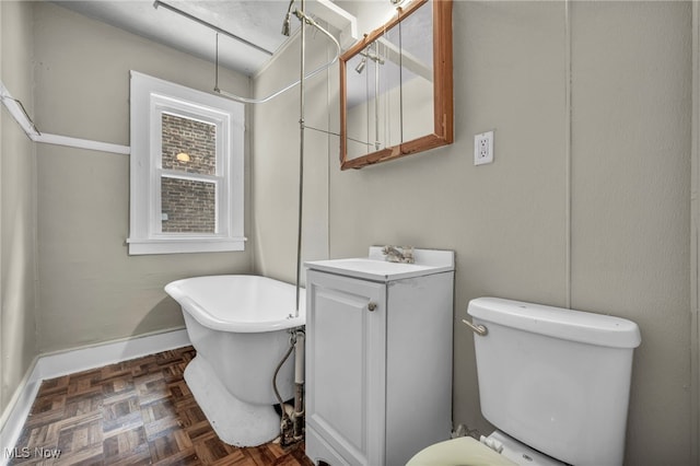 bathroom featuring vanity, parquet floors, a bathtub, and toilet