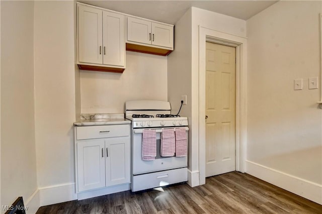 kitchen with dark hardwood / wood-style floors, white cabinets, and white gas range oven