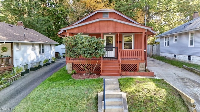 bungalow-style home with covered porch and a front lawn