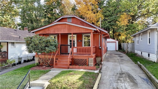 bungalow-style house with a garage, an outdoor structure, a front lawn, and a porch