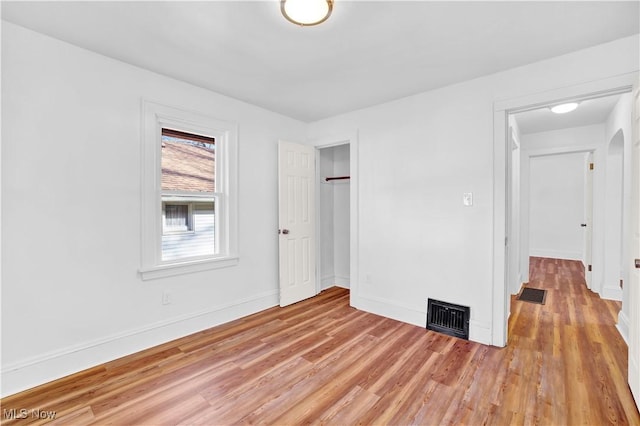 unfurnished bedroom featuring light hardwood / wood-style flooring and a closet