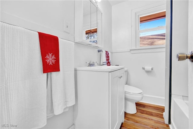 bathroom featuring vanity, hardwood / wood-style flooring, a shower, and toilet