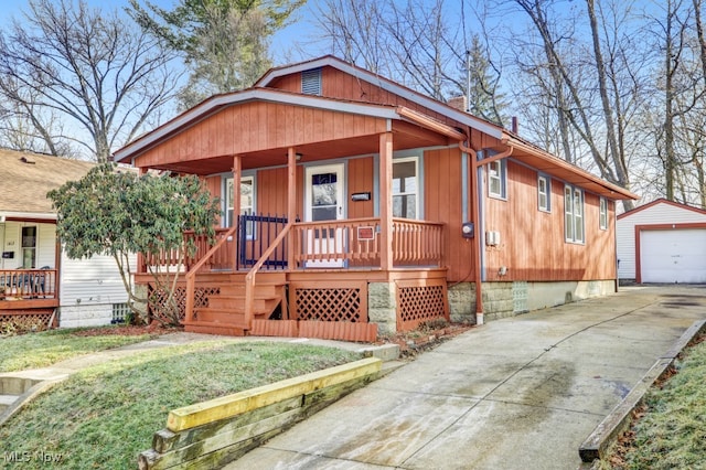 view of front of home with an outbuilding, a garage, covered porch, and a front yard