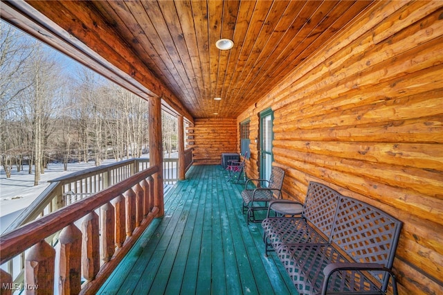 snow covered deck featuring a porch