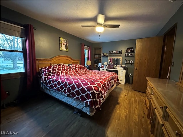 bedroom with hardwood / wood-style flooring, ceiling fan, and a textured ceiling