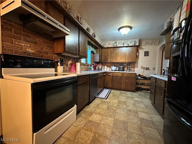 kitchen featuring electric range oven, dishwasher, sink, dark brown cabinetry, and black fridge