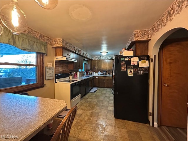 kitchen with sink, white electric range, black refrigerator, dark brown cabinetry, and decorative backsplash