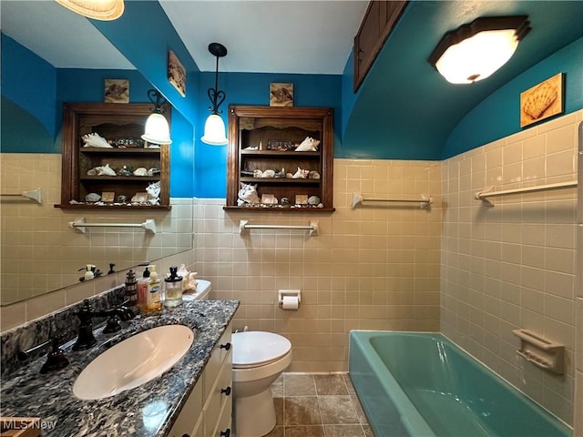 bathroom featuring tile patterned flooring, vanity, tile walls, and toilet