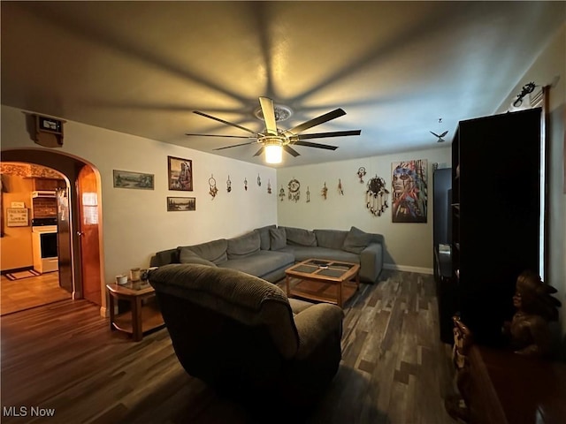 living room with ceiling fan and dark hardwood / wood-style flooring