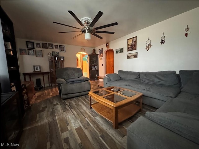 living room featuring ceiling fan and dark hardwood / wood-style flooring