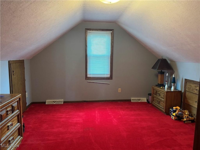 additional living space featuring lofted ceiling, carpet floors, and a textured ceiling