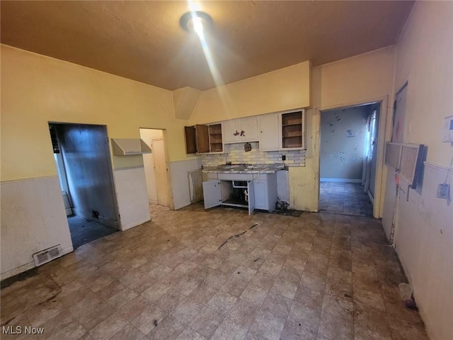 kitchen with tasteful backsplash and white cabinetry