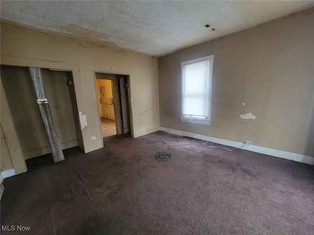 unfurnished bedroom featuring dark colored carpet