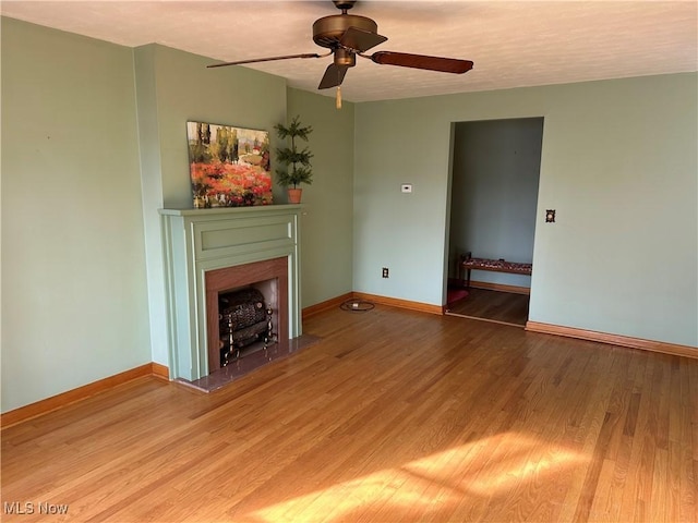 unfurnished living room with wood-type flooring and ceiling fan