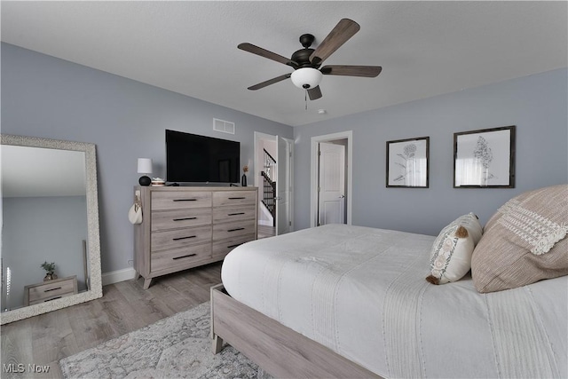 bedroom with light hardwood / wood-style floors and ceiling fan