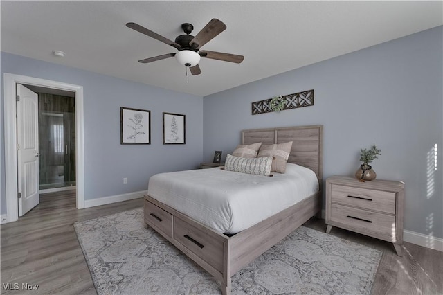 bedroom with ceiling fan, hardwood / wood-style floors, and ensuite bath