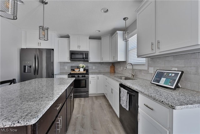 kitchen featuring stainless steel appliances, pendant lighting, and white cabinets