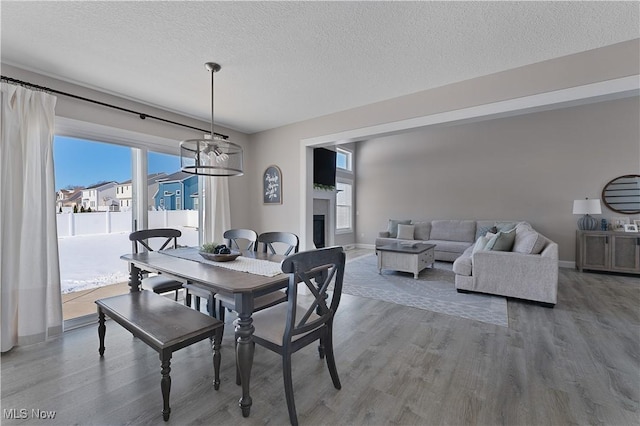 dining area with wood-type flooring and a textured ceiling