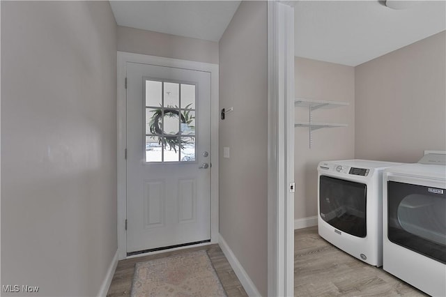 laundry area with separate washer and dryer and light hardwood / wood-style flooring