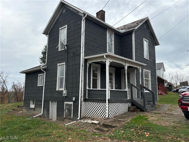 view of side of home featuring a lawn and a porch