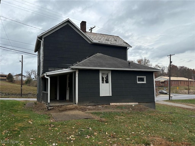 rear view of property featuring a lawn