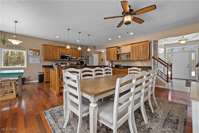 dining space with dark wood-type flooring, ceiling fan, and a textured ceiling