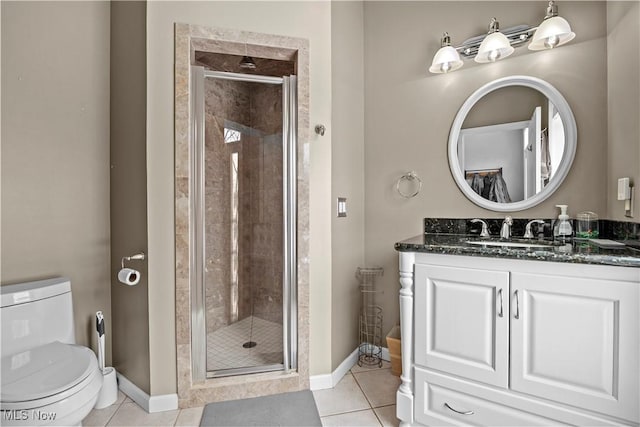 bathroom with tile patterned flooring, vanity, toilet, and walk in shower