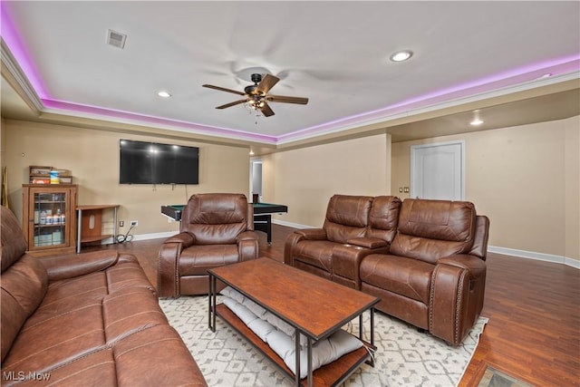 living room with crown molding, a tray ceiling, light hardwood / wood-style floors, and ceiling fan