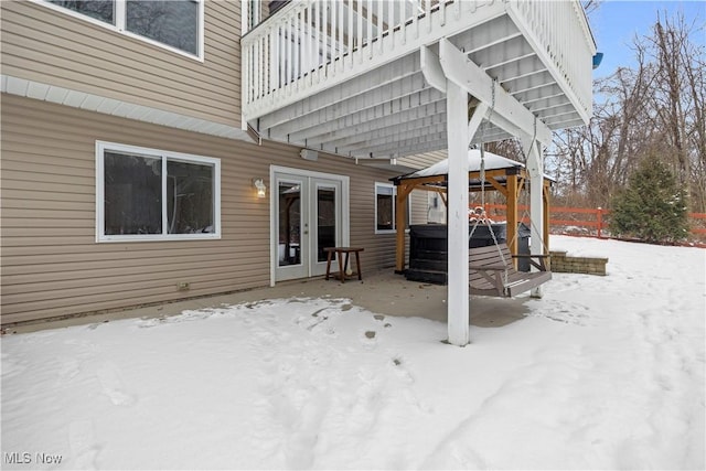 snow covered patio with a gazebo and a hot tub