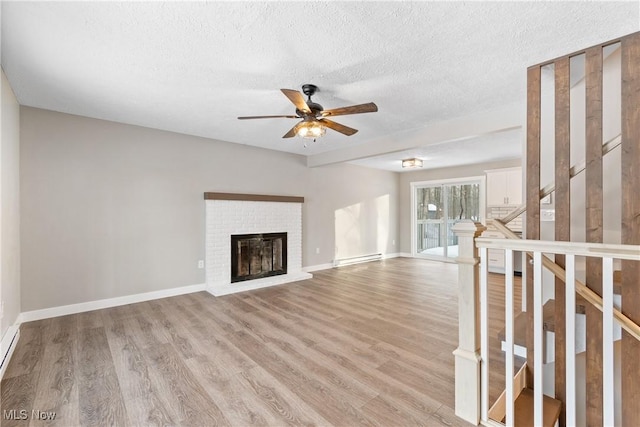 unfurnished living room with a fireplace, a baseboard radiator, ceiling fan, a textured ceiling, and light hardwood / wood-style flooring