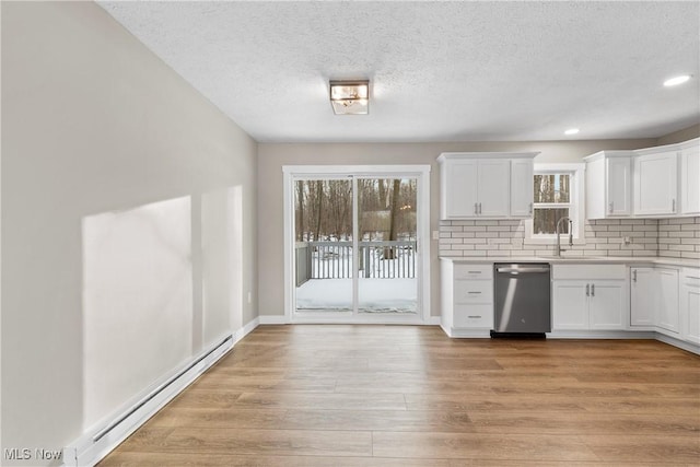 kitchen featuring dishwasher, a baseboard radiator, white cabinets, decorative backsplash, and light hardwood / wood-style floors