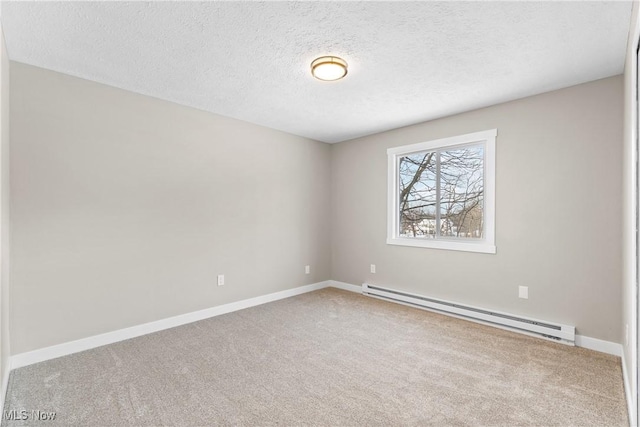 carpeted empty room with a baseboard heating unit and a textured ceiling