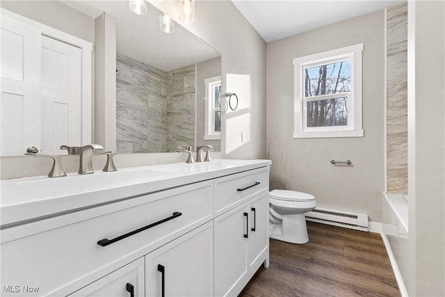 bathroom featuring vanity, wood-type flooring, toilet, and baseboard heating