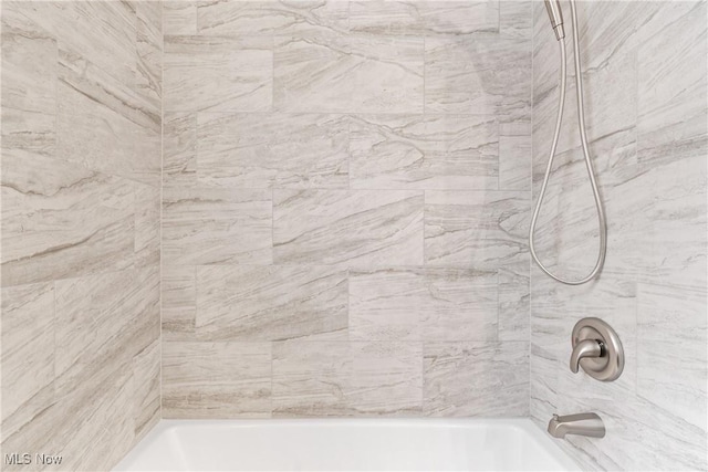 room details with tiled shower / bath combo