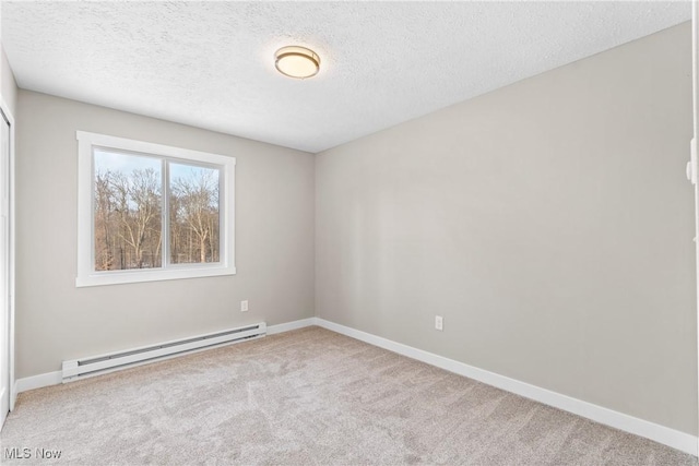 carpeted empty room with a baseboard radiator and a textured ceiling