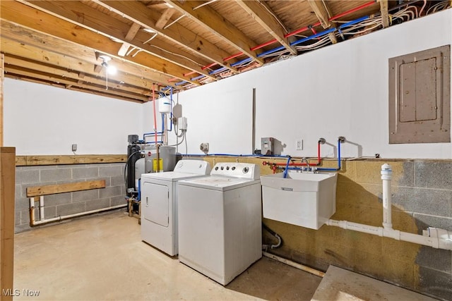 clothes washing area with separate washer and dryer, electric panel, and sink