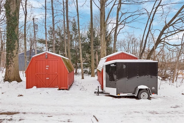 yard layered in snow with a storage unit