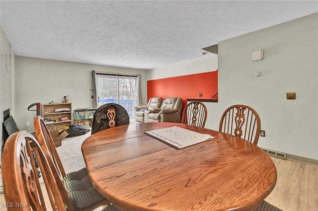 dining area featuring hardwood / wood-style floors and a textured ceiling