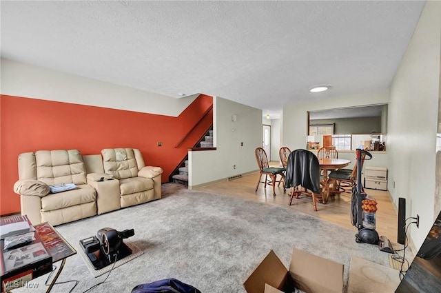 living room featuring light hardwood / wood-style floors and a textured ceiling